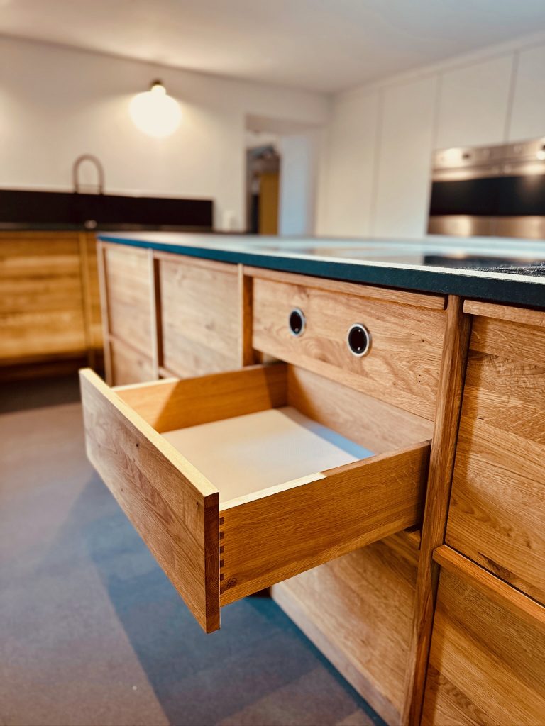 Offene Schublade aus Eiche unter dem Kochfeld