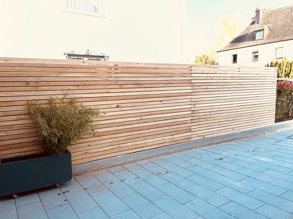 Eine Einfahrt für Autos mit Holzbalken verschönert