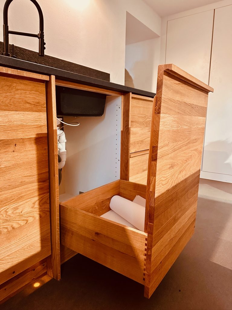 Offene Mülleimerschublade aus Eiche - schwarze Arbeitsplatte